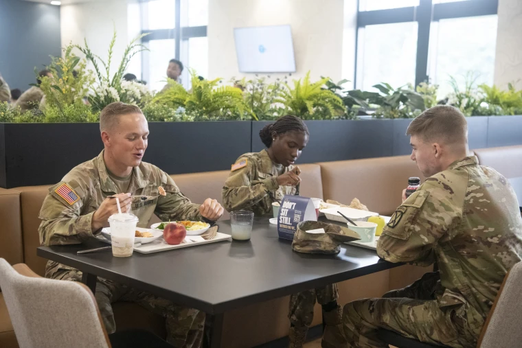 Carson Gant, Taye Lewis and Joshua Holtcamp eat lunch at the Belvedere Bistro on base at Fort Drum, NY, on July 28, 2026.